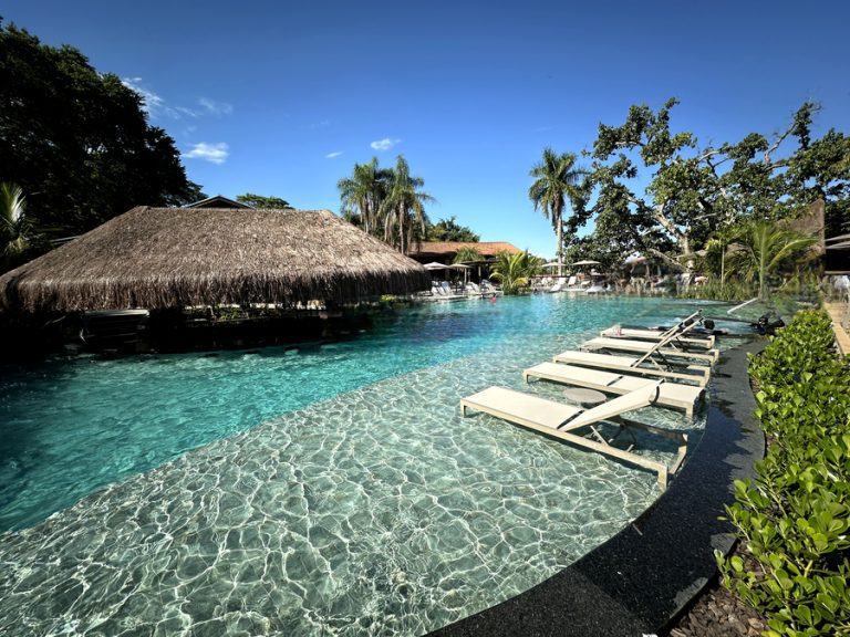 Piscina ampla e convidativa em resort, hotel ou pousada, ideal para relaxar e se refrescar.