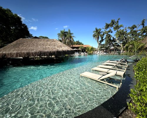 Piscina ampla e convidativa em resort, hotel ou pousada, ideal para relaxar e se refrescar.